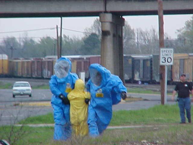 Two fire fighters training to take a victim away from a dangerous situation.